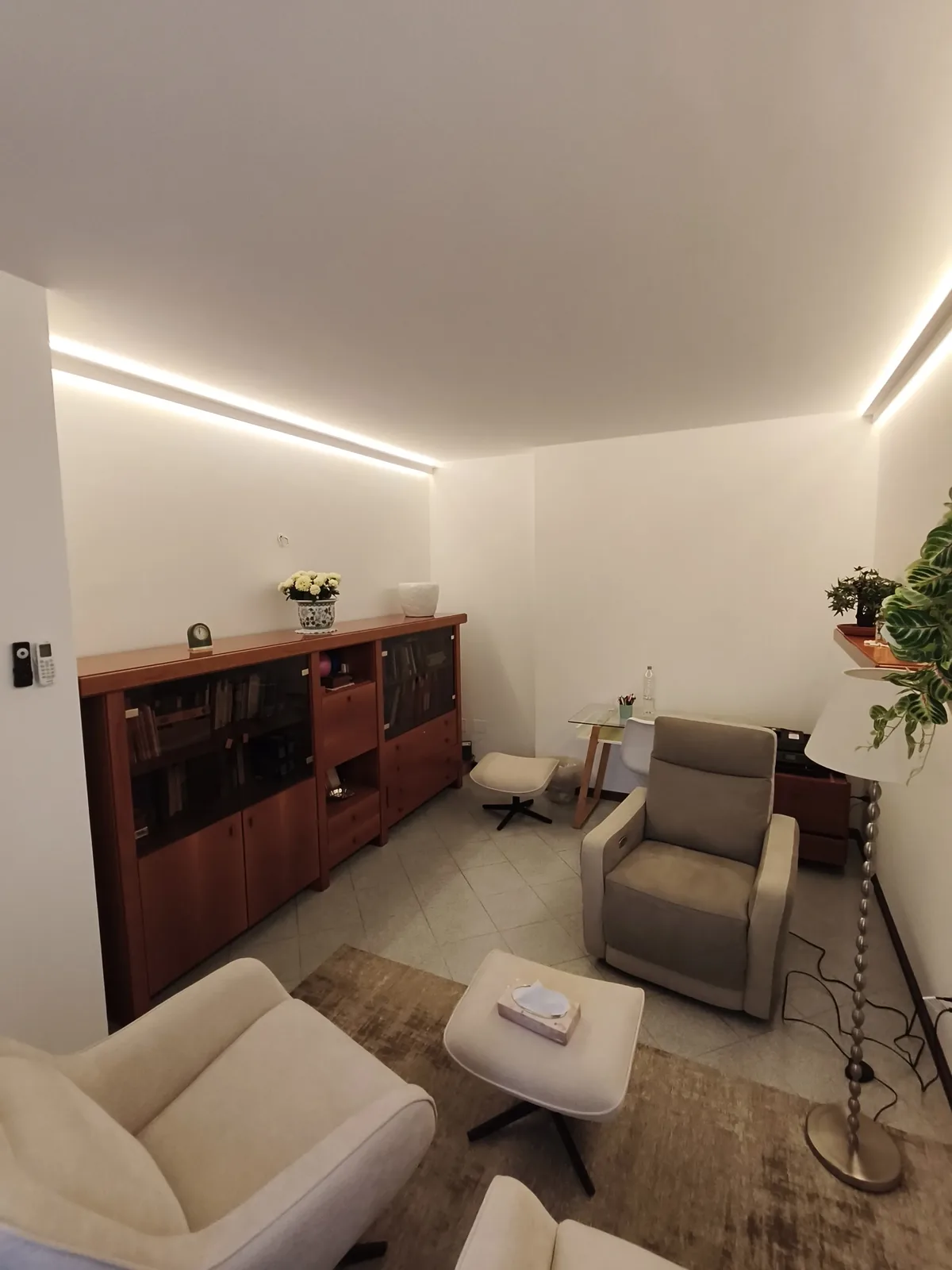 Studio colloqui, parete libreria illuminata dalla luce LED indiretta a soffitto