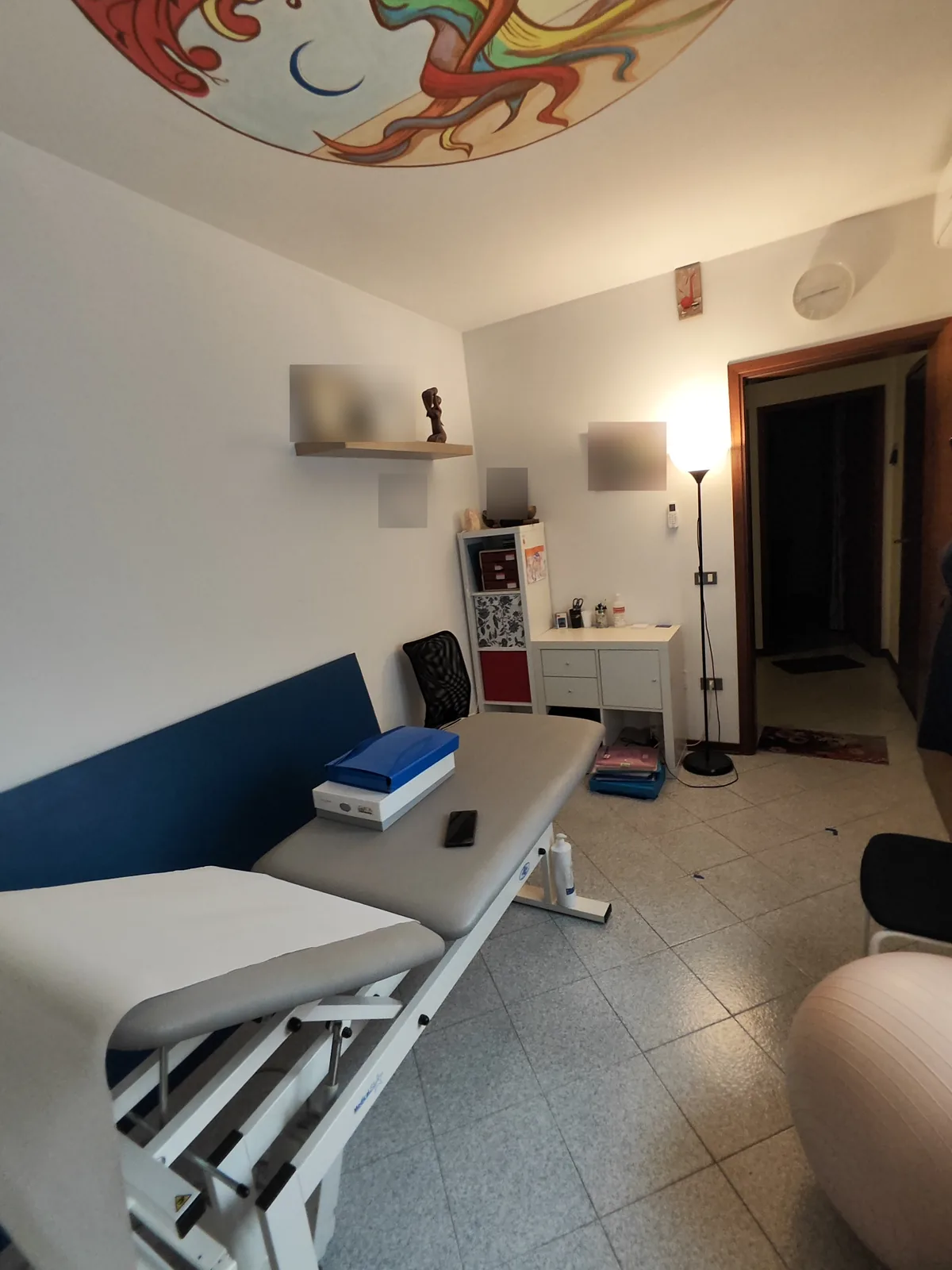 Secondo studio prima dell'intervento, vista verso la porta con piantana accesa